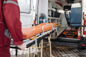 A paramedic loads a stretcher into an ambulance