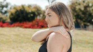 A woman holding her shoulder suffers from a permanent disability