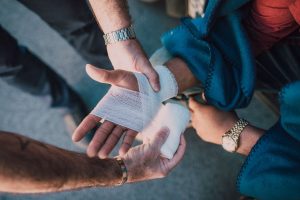 A first responder treats a New Haven personal injury by wrapping a victim's wrist in gauze